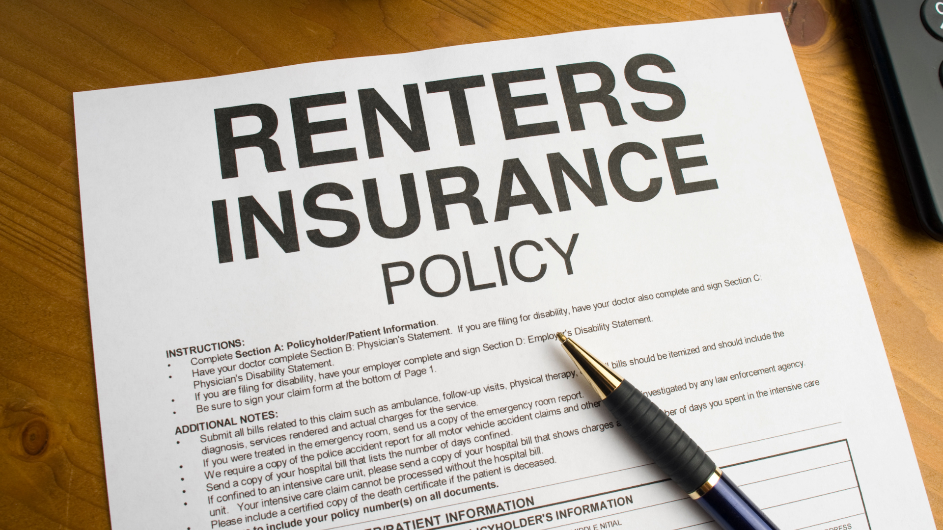 Renters insurance policy on a wood table with pen.