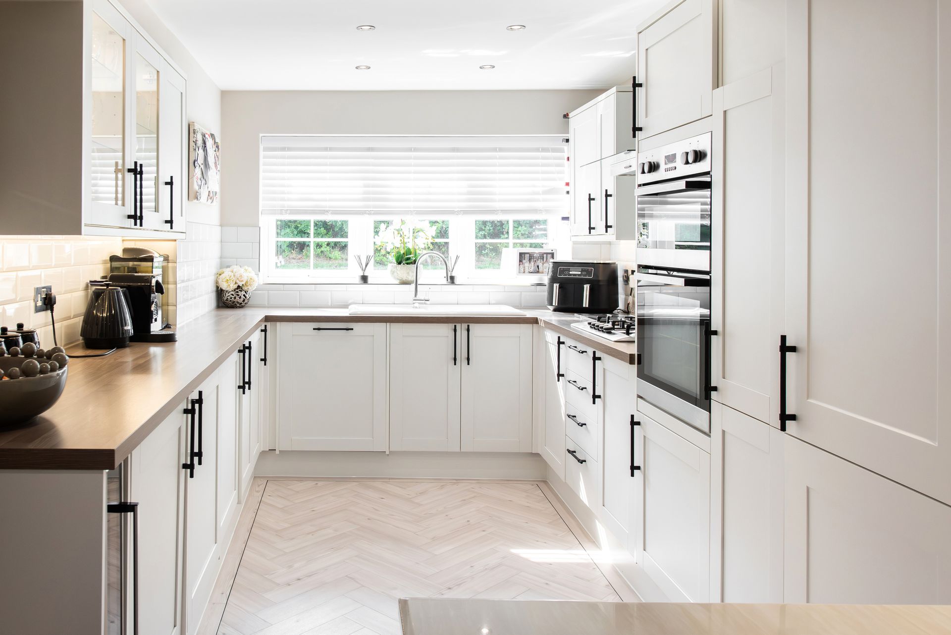 A kitchen with white cabinets , wooden counter tops , and stainless steel appliances. A kitchen with white cabinets , wooden counter tops , and stainless steel appliances.