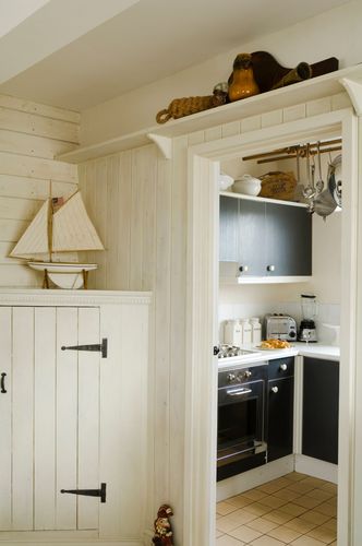 A white sailboat sits on a shelf in a kitchen A white sailboat sits on a shelf in a kitchen