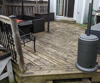 A wooden deck with furniture and a heater on it. A wooden deck with furniture and a heater on it.