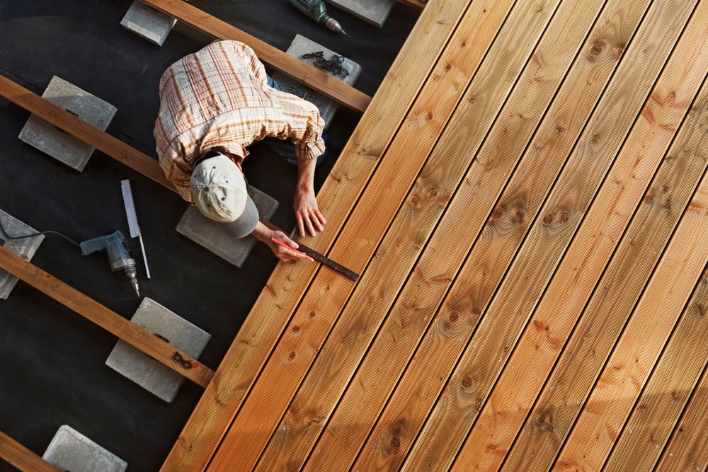 Person Installing Wooden Deck Boards Outdoors — C & S Building In Bentley, NSW
