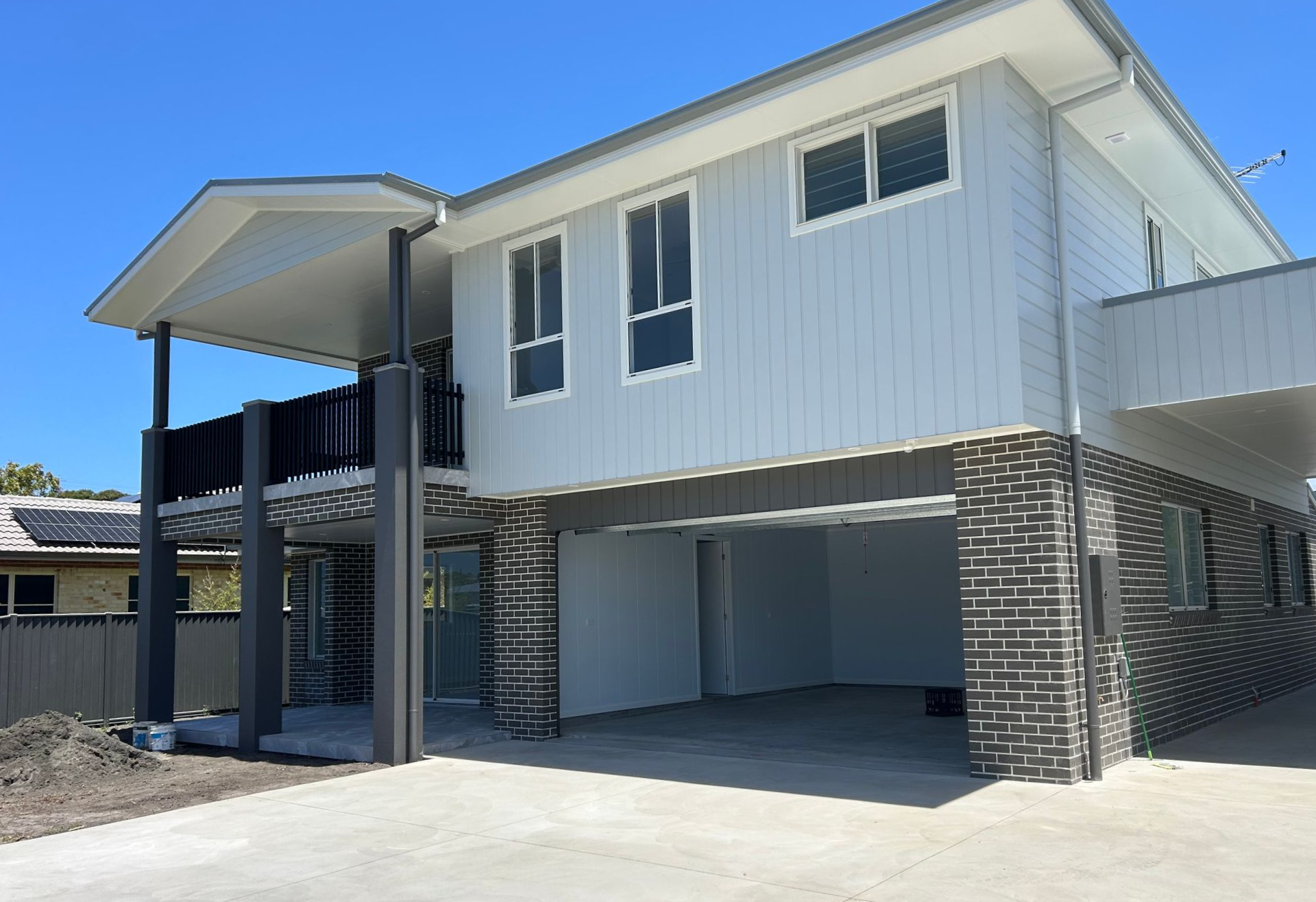 Two-story house with covered balcony and garage, grey and black exterior — C & S Building In Bentley, NSW