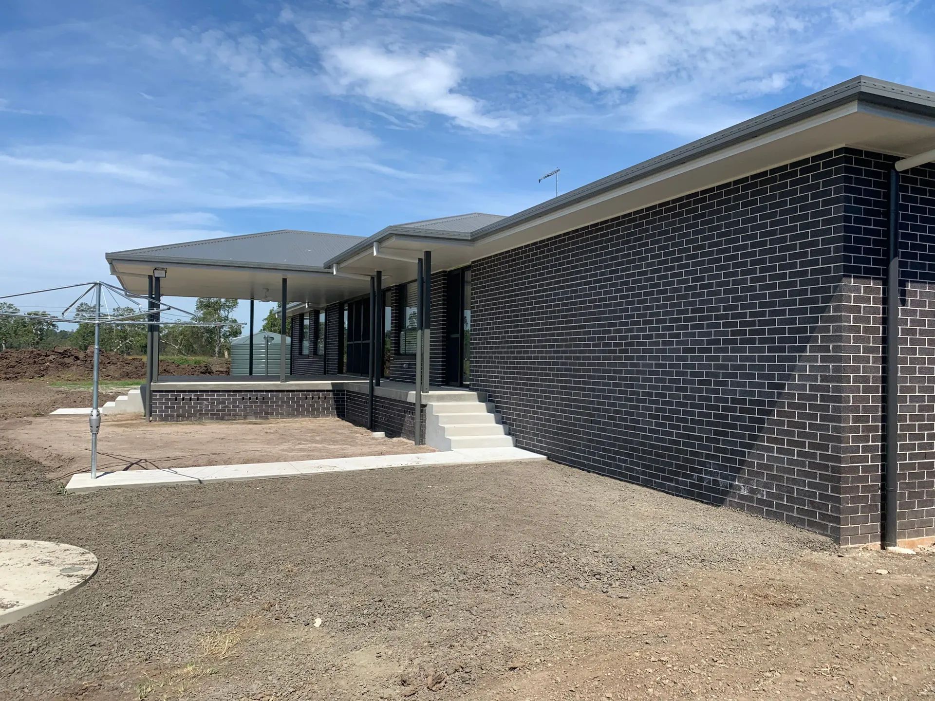 Modern, single-story house with dark brick exterior, porch, and a gray roof — C & S Building In Bentley, NSW