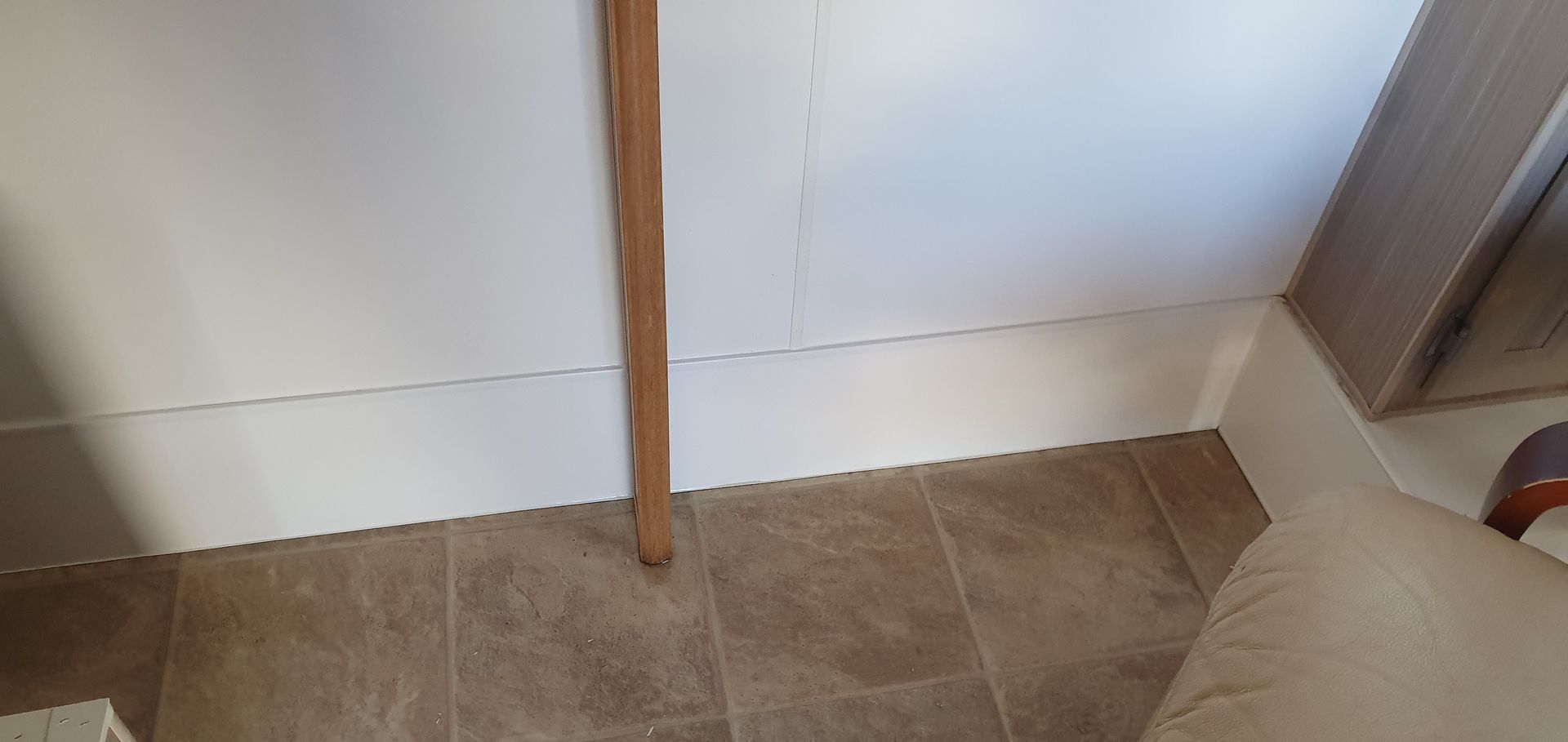 Red Fox repairing a white wall panel and tiled floor.