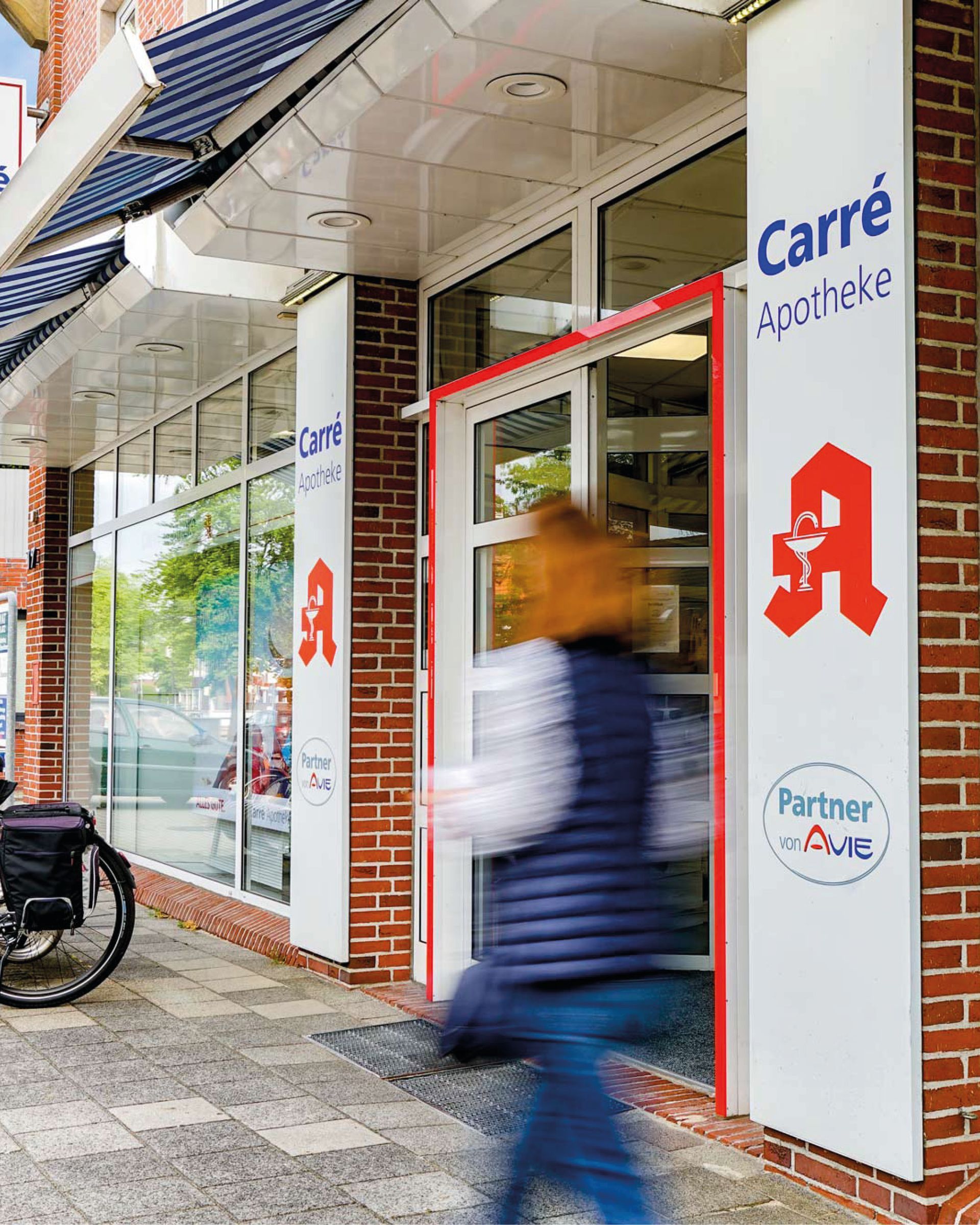 Ein verschwommenes Bild einer Person, die eine Apotheke betritt