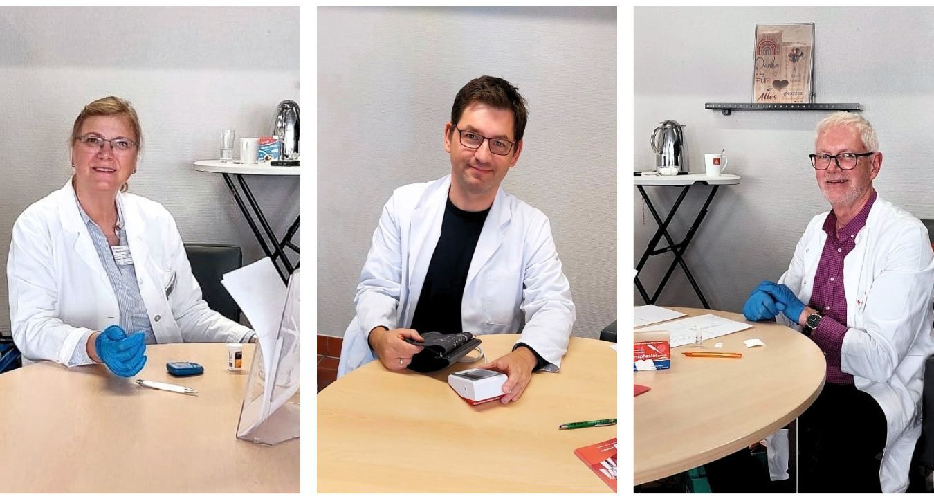 Ein Mann und zwei Frauen stehen in einer Apotheke.