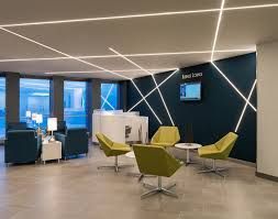 A lobby with chairs , tables and a television on the wall. Project completed by AARONS.