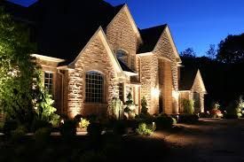 A large brick house is lit up at night light project completed by AARONS lighting & Design. 