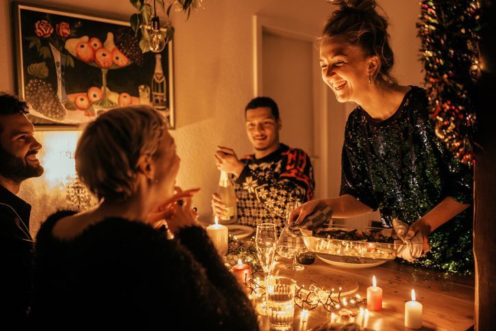 Un gruppo di persone è seduto a un tavolo e sta consumando la cena di Natale.