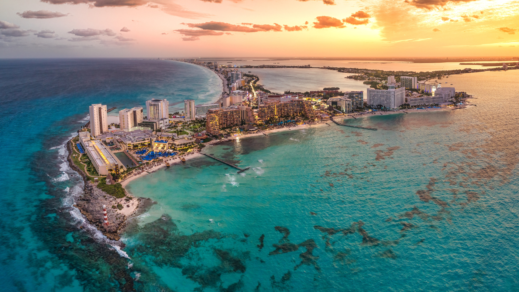 An aerial view of a small island in the middle of the ocean at sunset.