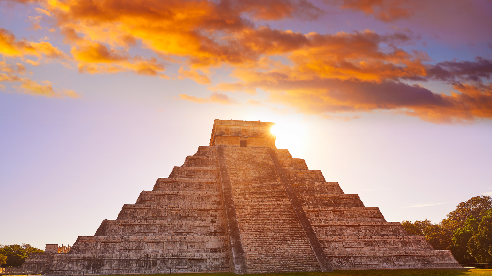 The sun is shining through the clouds over the pyramid.