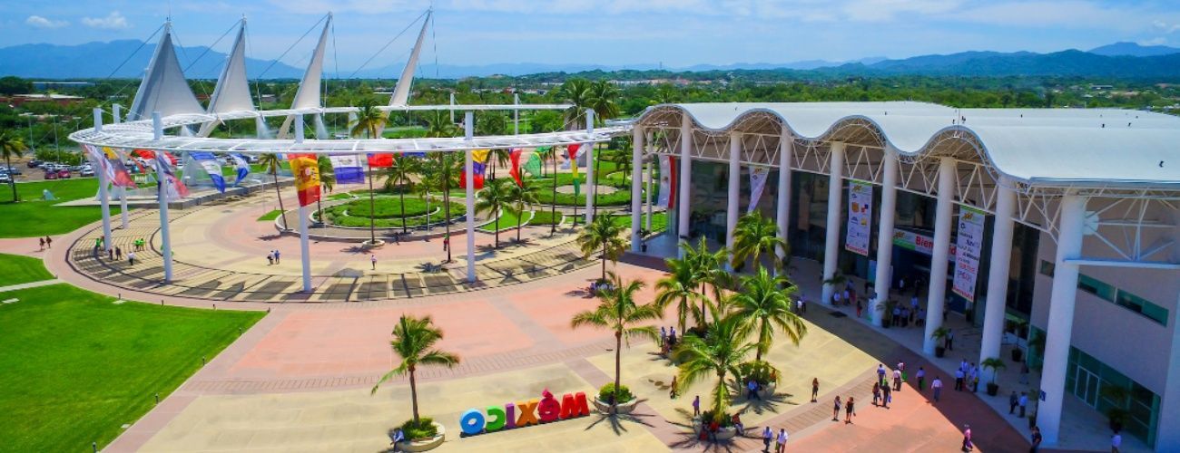 An aerial view of a large building with palm trees in front of it.