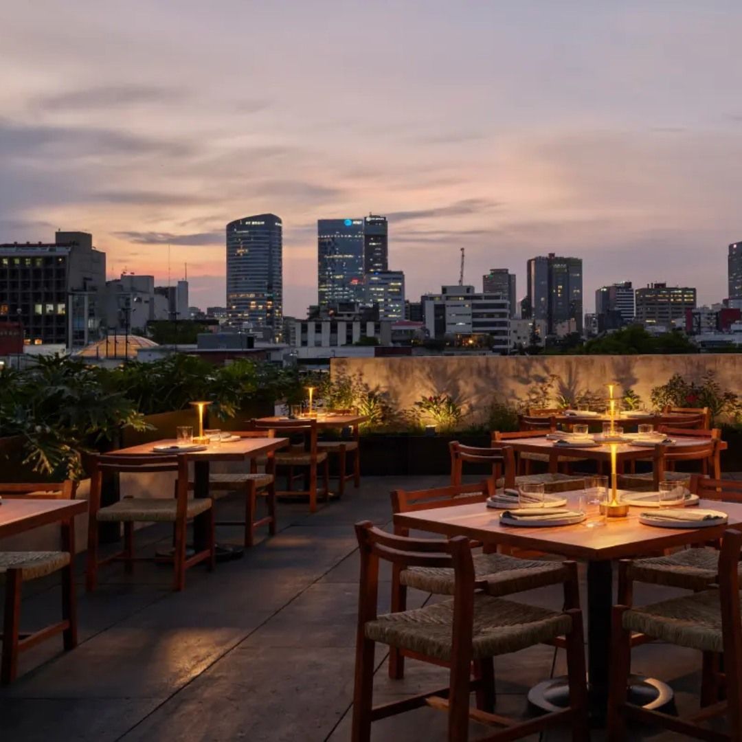 A row of tables and chairs with a city skyline in the background