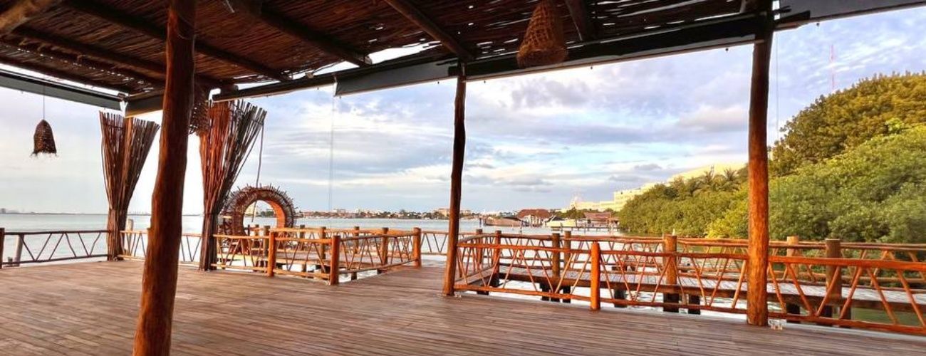 A wooden deck with a roof overlooking a body of water.