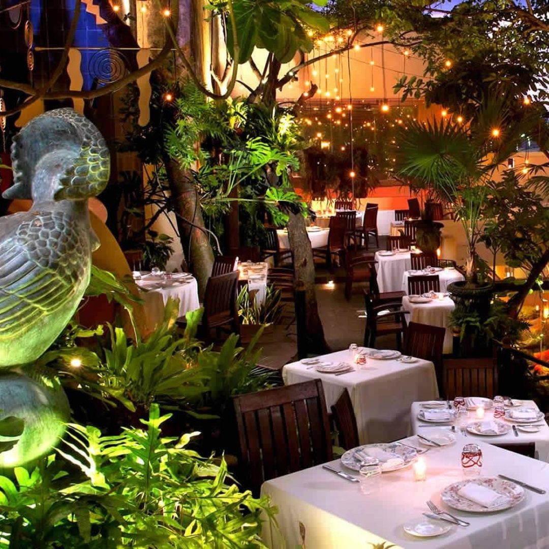 A restaurant with tables and chairs and a statue of a bird