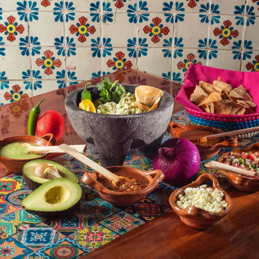A table topped with bowls of food and a mortar and pestle