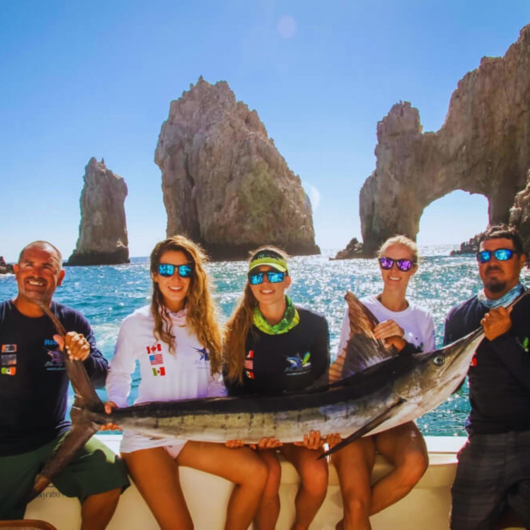A group of people sitting on a boat holding a large fish