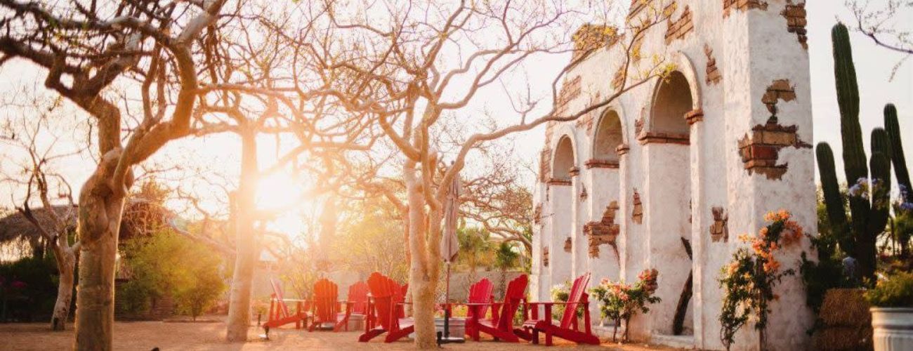 A group of red chairs are sitting in front of a white building.