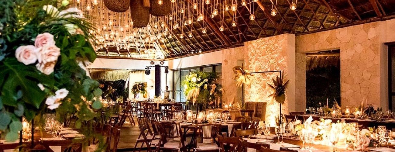 A large dining room with tables and chairs set up for a wedding reception.