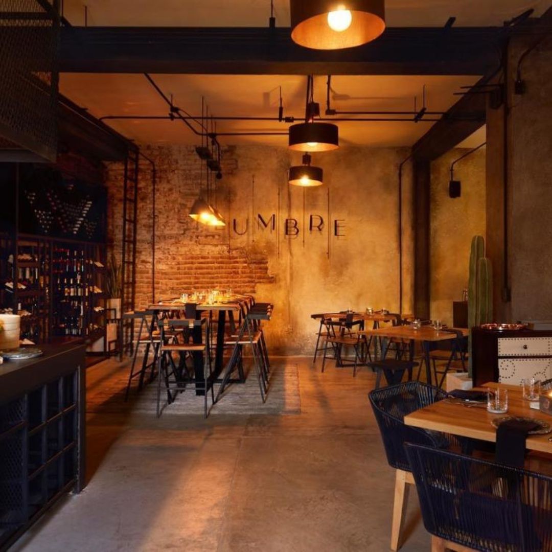 A restaurant with tables and chairs and the word umbra on the wall