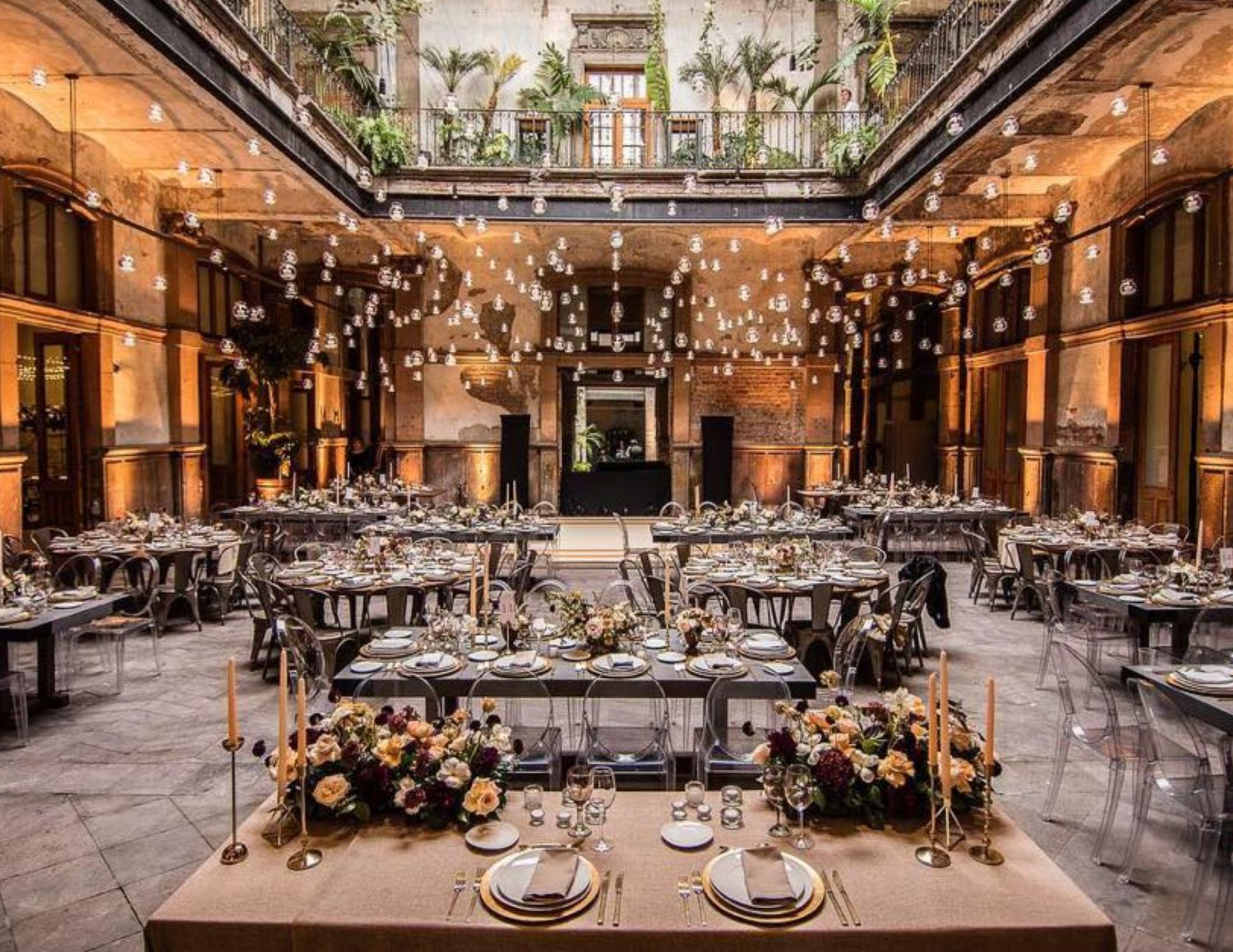 A large room with tables and chairs set up for a wedding reception.