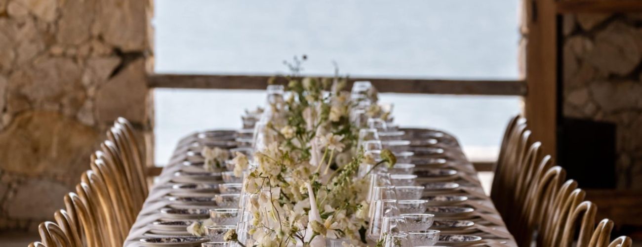 A long table with a vase of flowers on it.