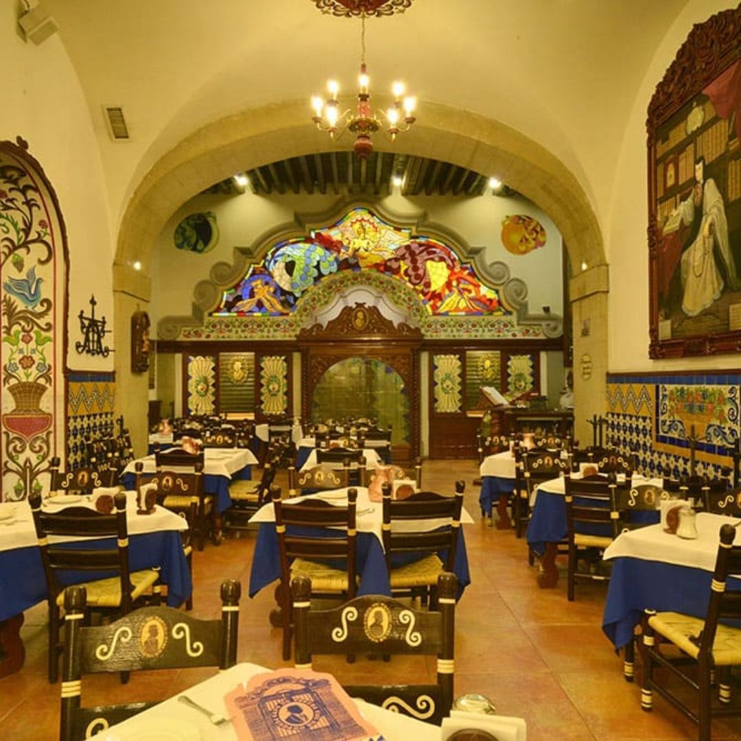 A restaurant with tables and chairs and a stained glass window