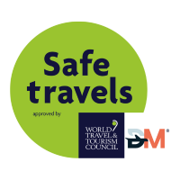 A green sticker that says safe travels approved by the world travel & tourism council