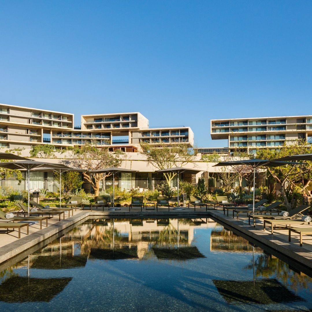 A large building with a pool in front of it