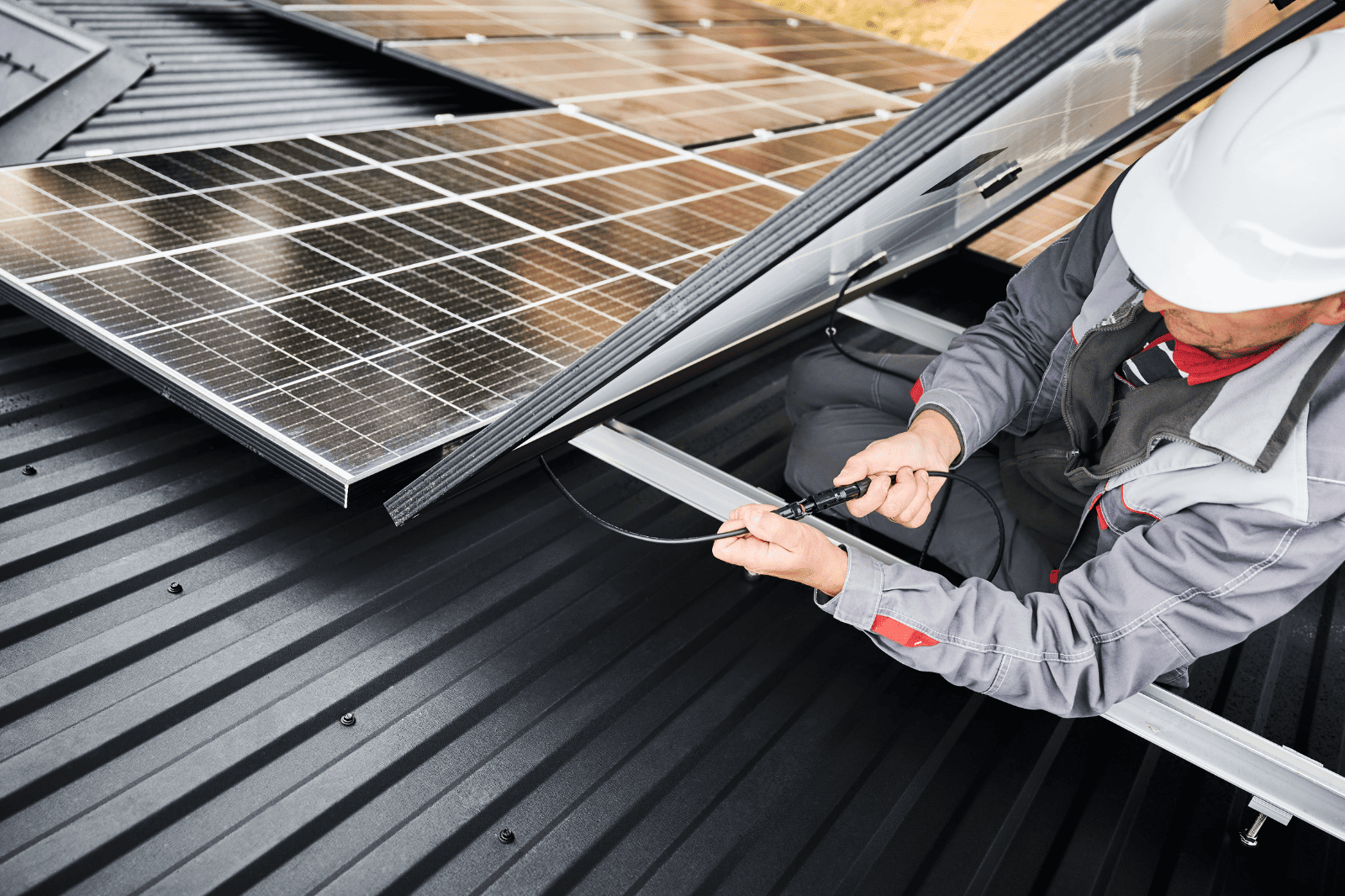 Two Men Are Installing Solar Panels on the Roof of a House — B2B Electrical and Solar In Currimundi, QLD