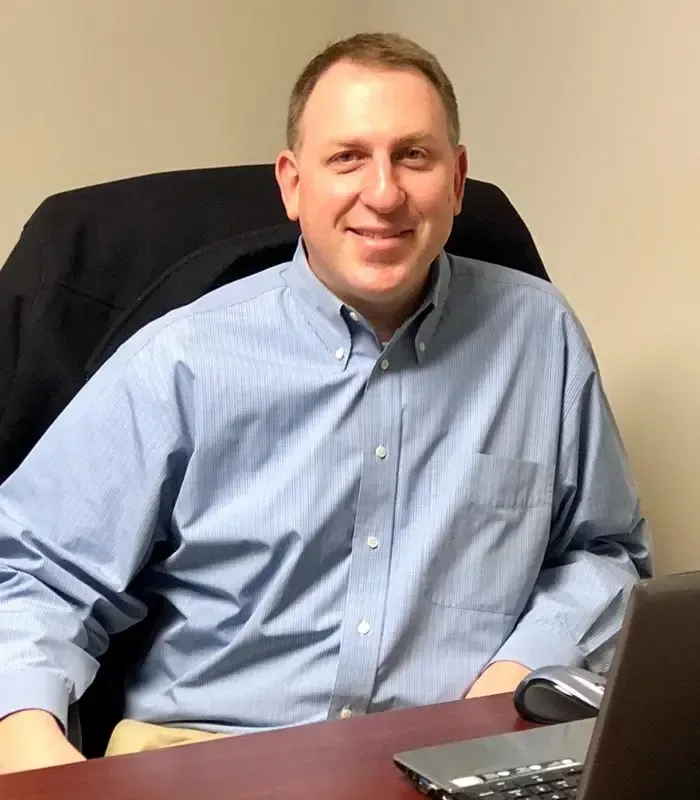 A man in a suit and tie is smiling for the camera.
