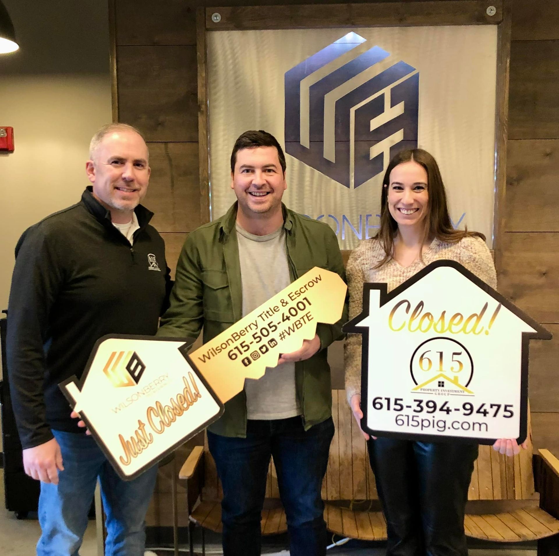 Real estate agent and clients holding