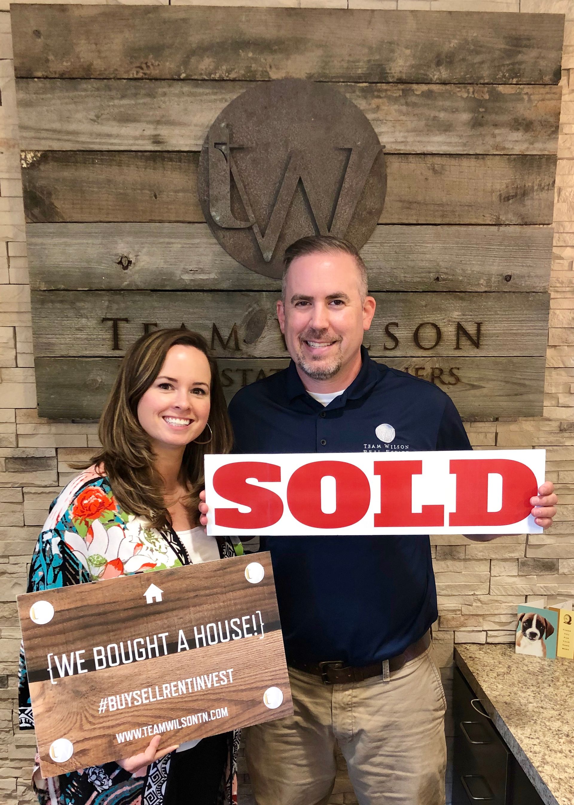 Real estate agent and client holding