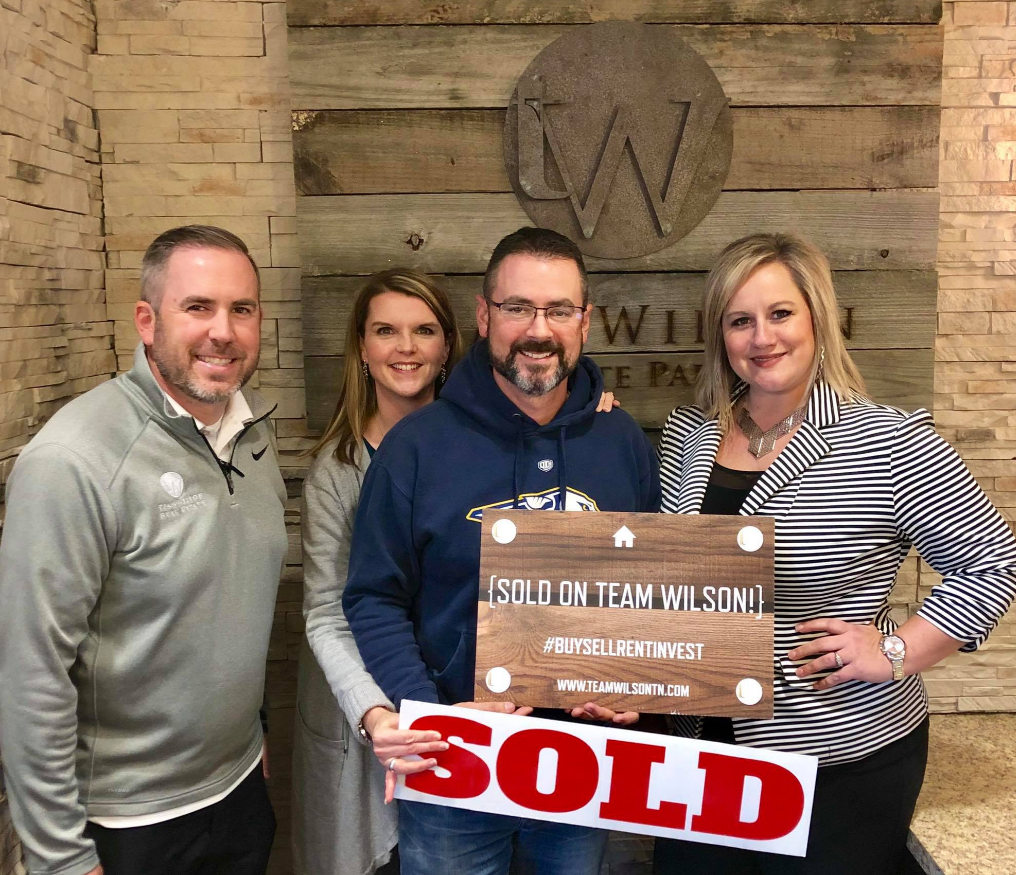 Real estate agents and clients holding
