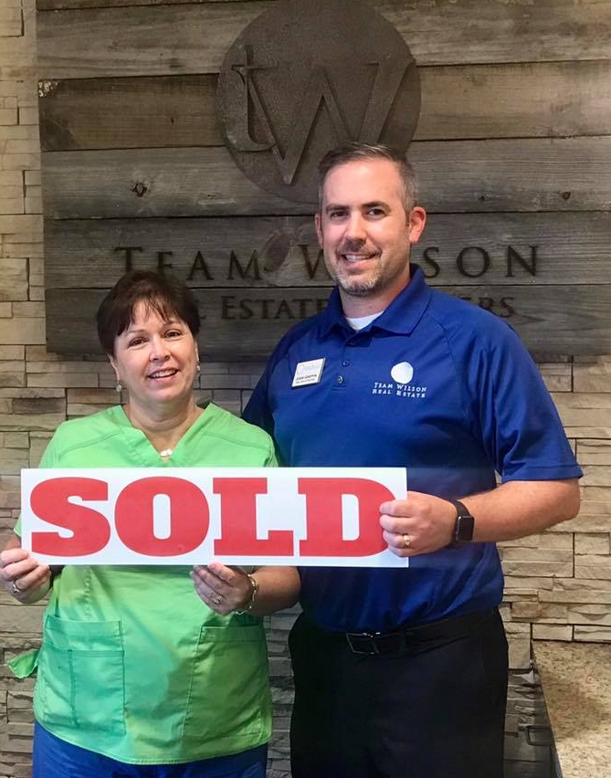 Real estate agent and client holding