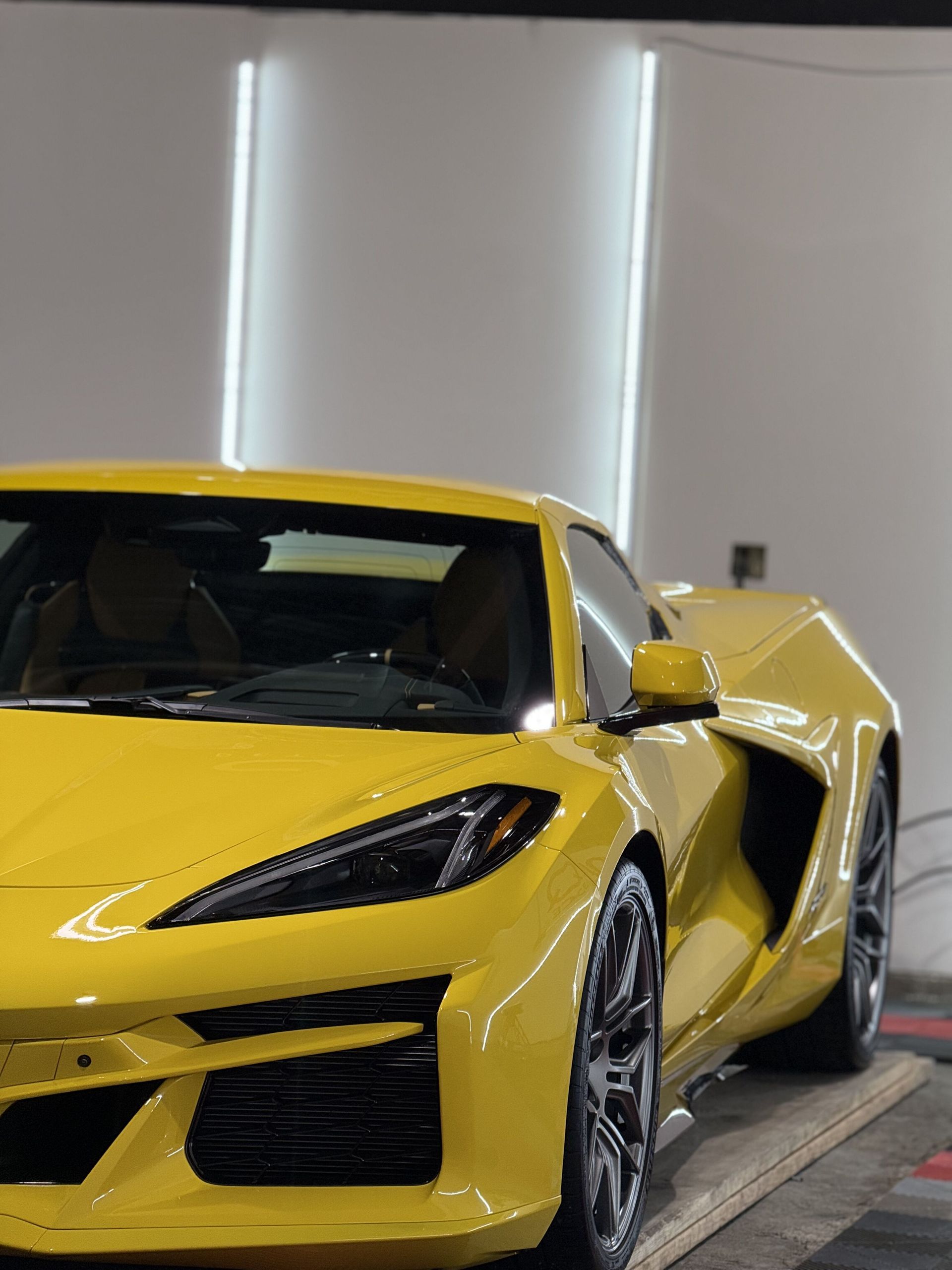 A yellow sports car is parked in a garage