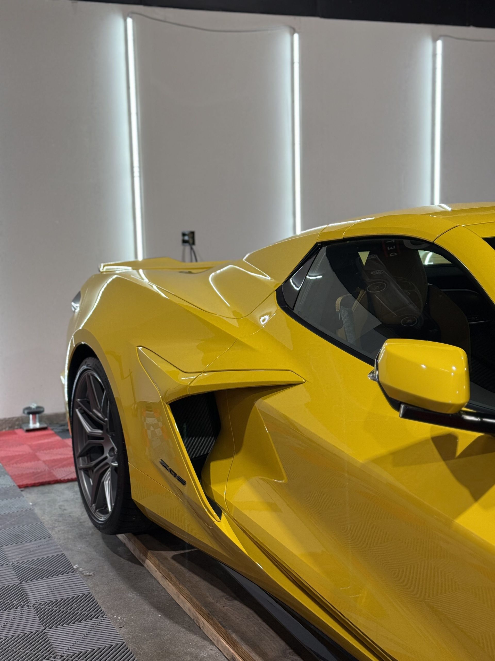 A yellow sports car is parked in a garage