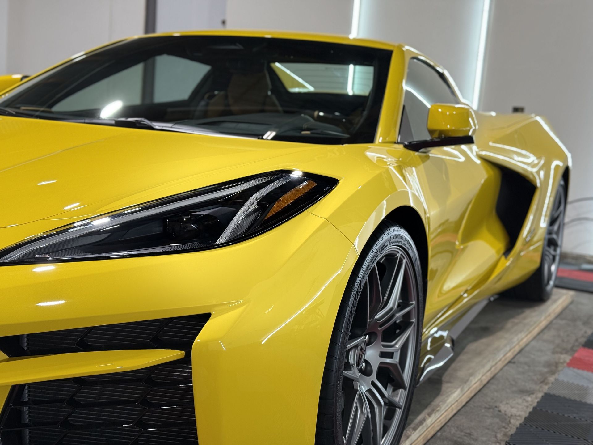 A yellow sports car is parked in a garage.