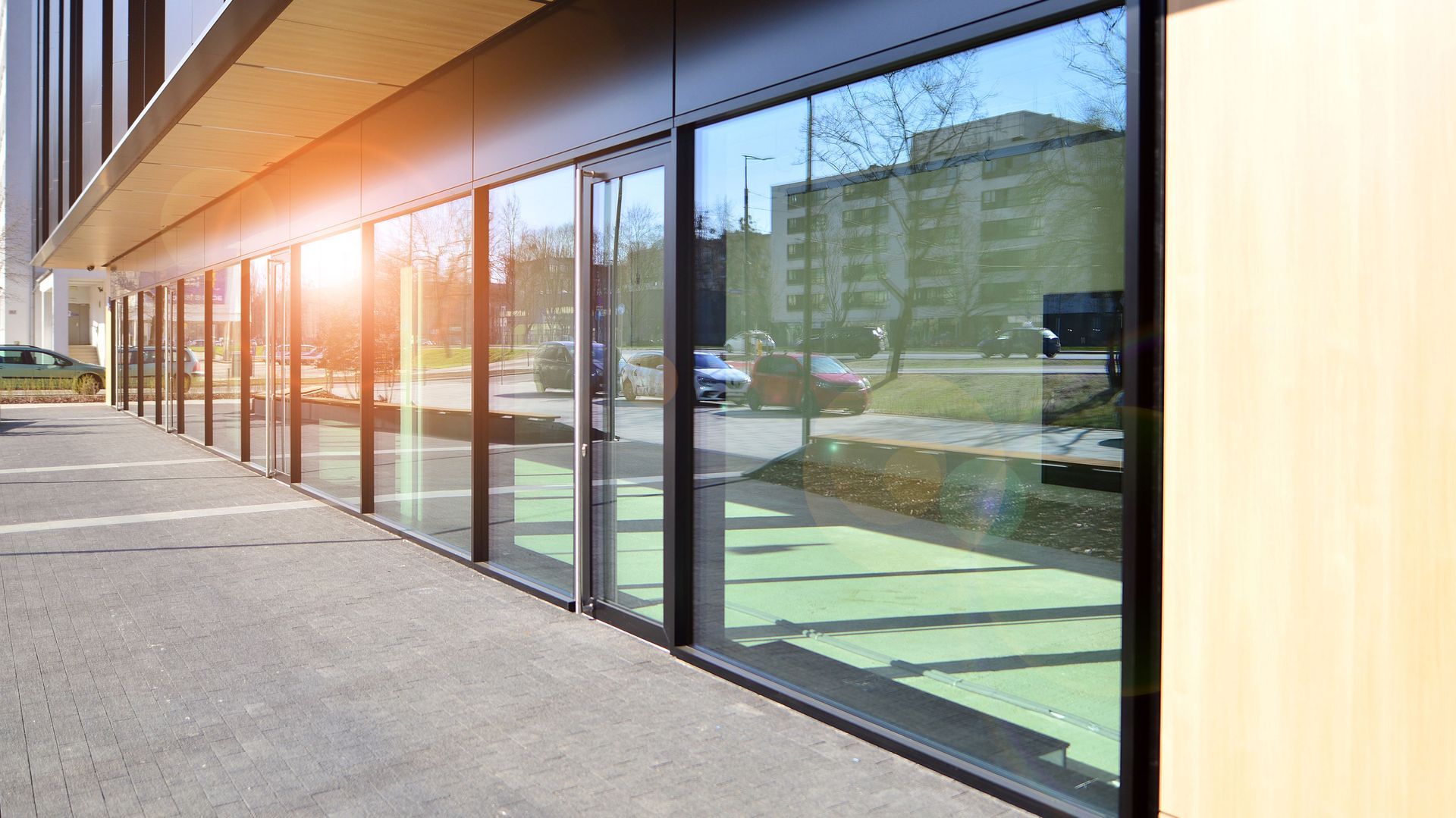 A building with a lot of windows and a parking lot in front of it.