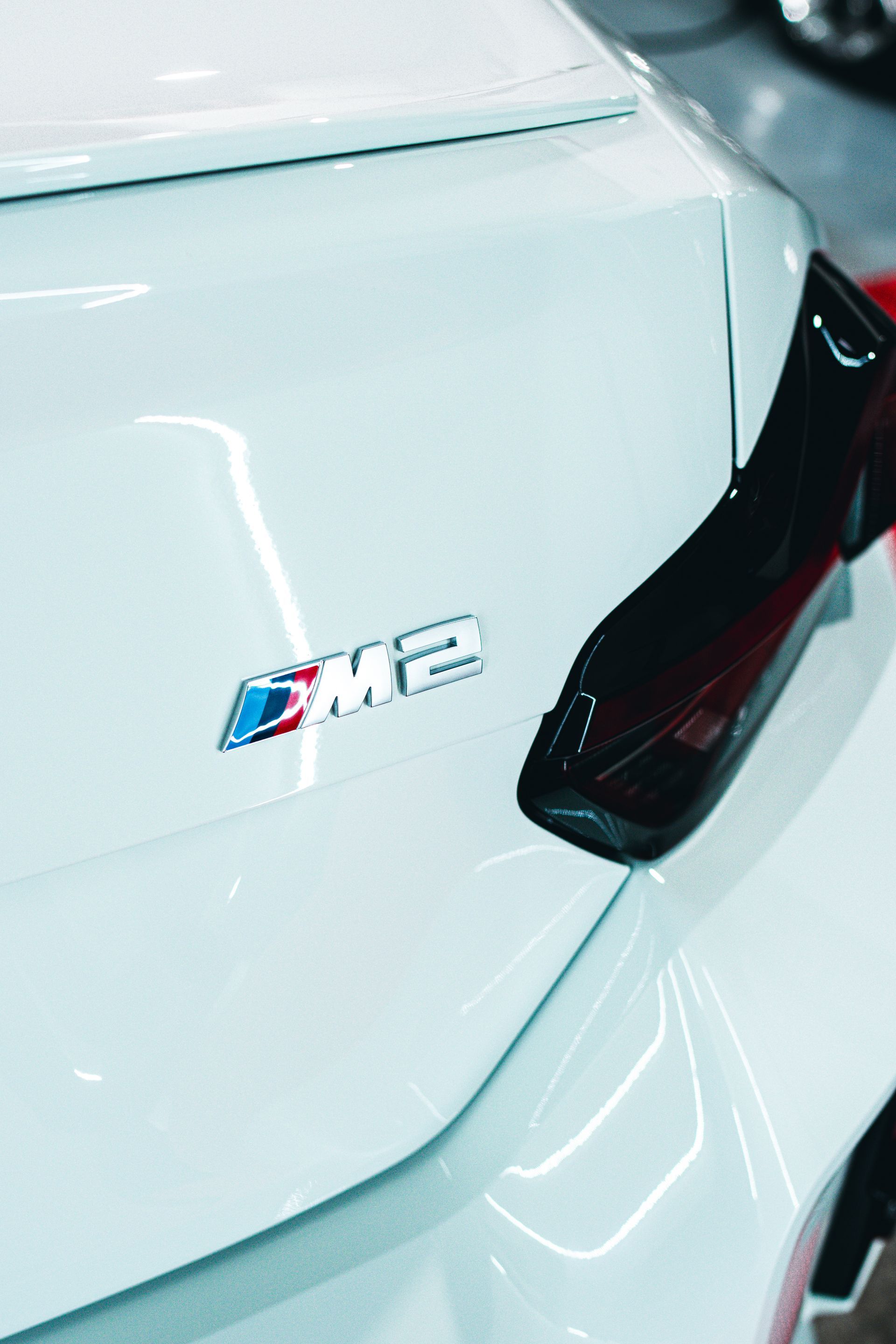 A close up of the back of a white car with a bmw logo on it.
