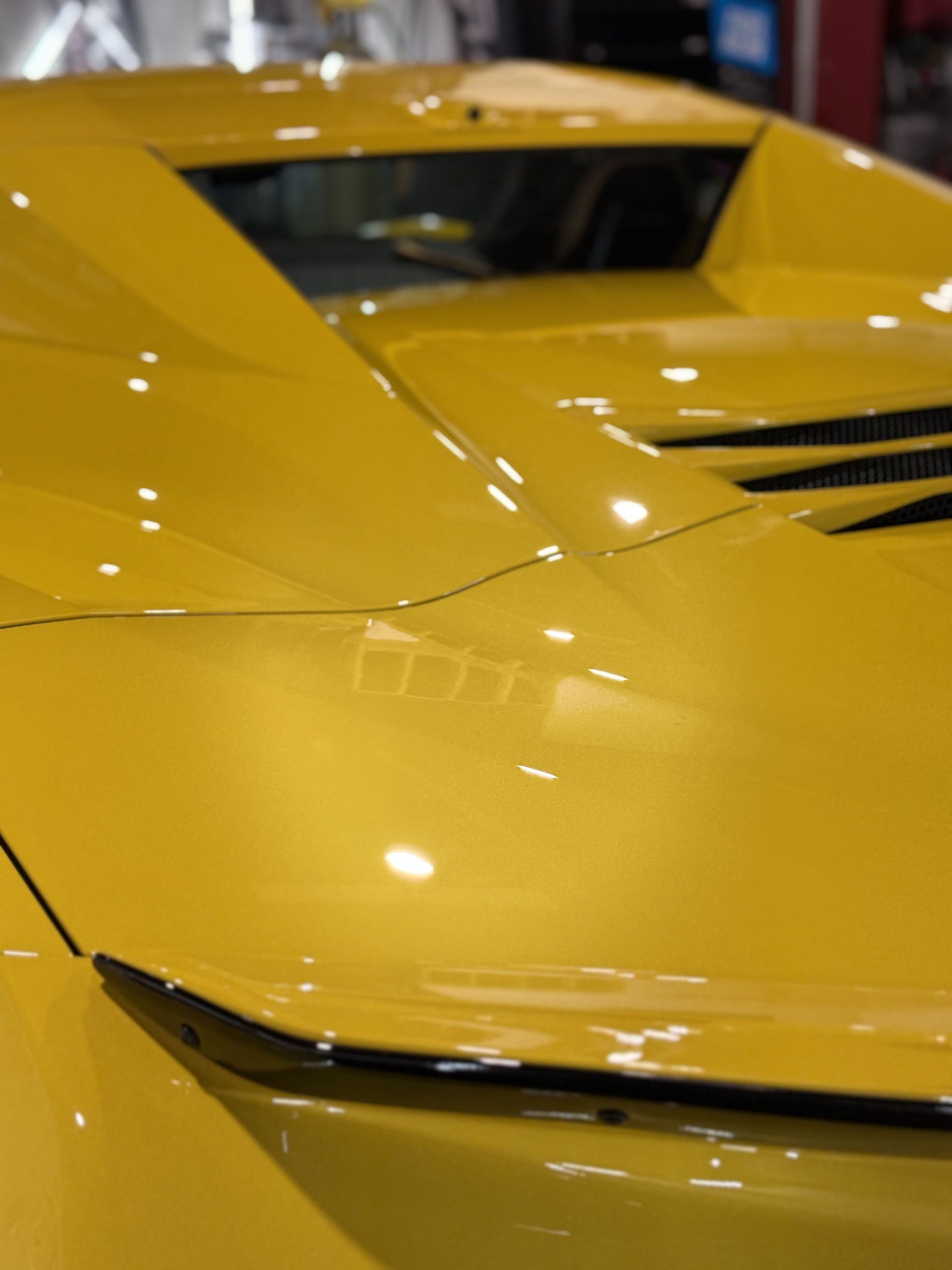 A close up of the hood of a yellow sports car