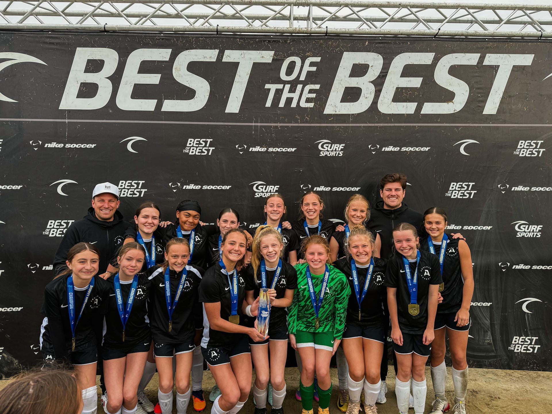 A soccer team from Advantage Academy posing with a trophy