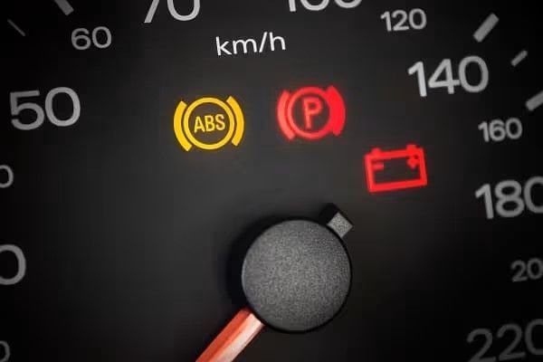 Car dashboard with illuminated warning lights: ABS, parking brake, and battery — Chris Albertini Automotive in North Lismore, NSW