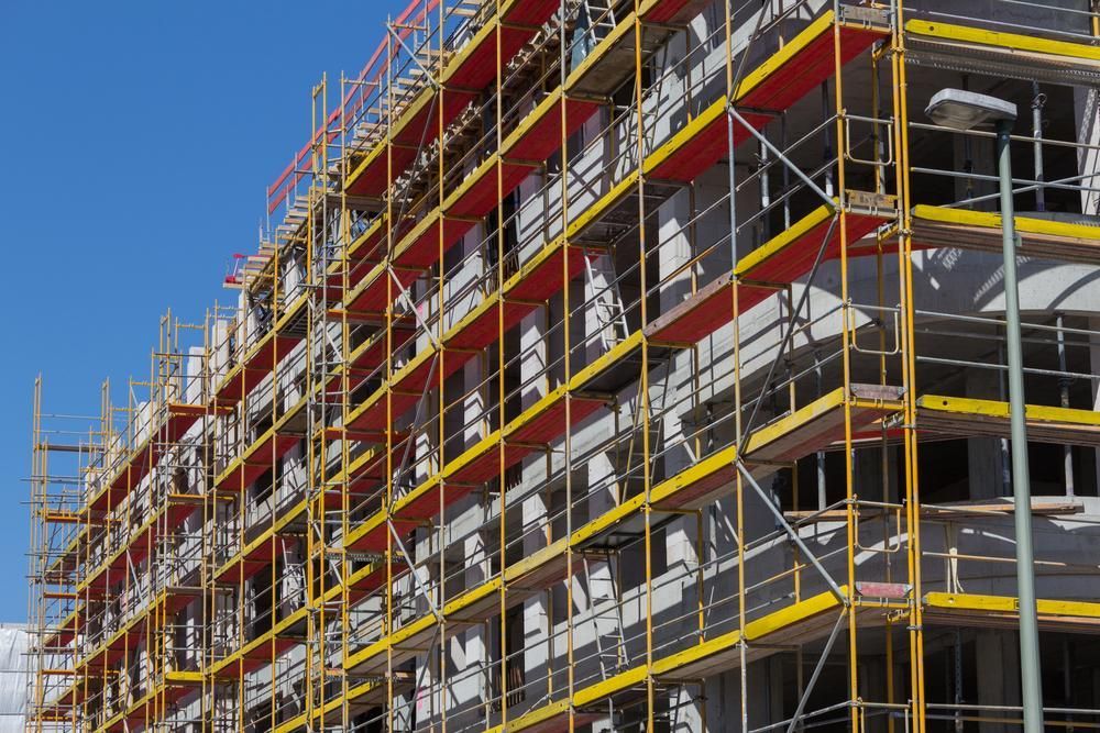 Building Under Construction With Yellow Scaffolding and Red Planks — NRS Scaffolding Pty Ltd in Nambucca Heads, NSW