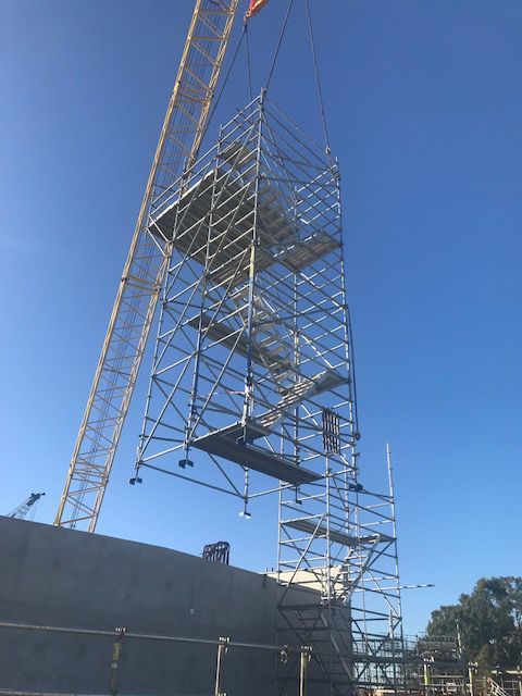 Crane Lifting a Tall, Silver Scaffolding Structure — NRS Scaffolding Pty Ltd in Harrington, NSW