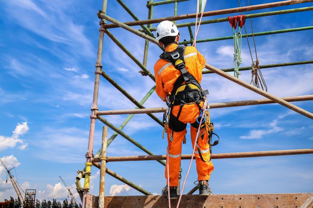 A Construction Worker is Standing on Top of a Scaffolding — NRS Scaffolding Pty Ltd in Grafton, NSW