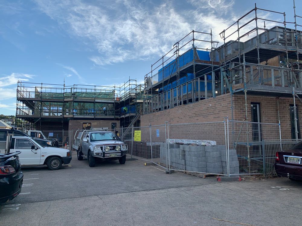 Construction Site With Brick Buildings, Scaffolding, and Parked Vehicles — NRS Scaffolding Pty Ltd in Taree, NSW
