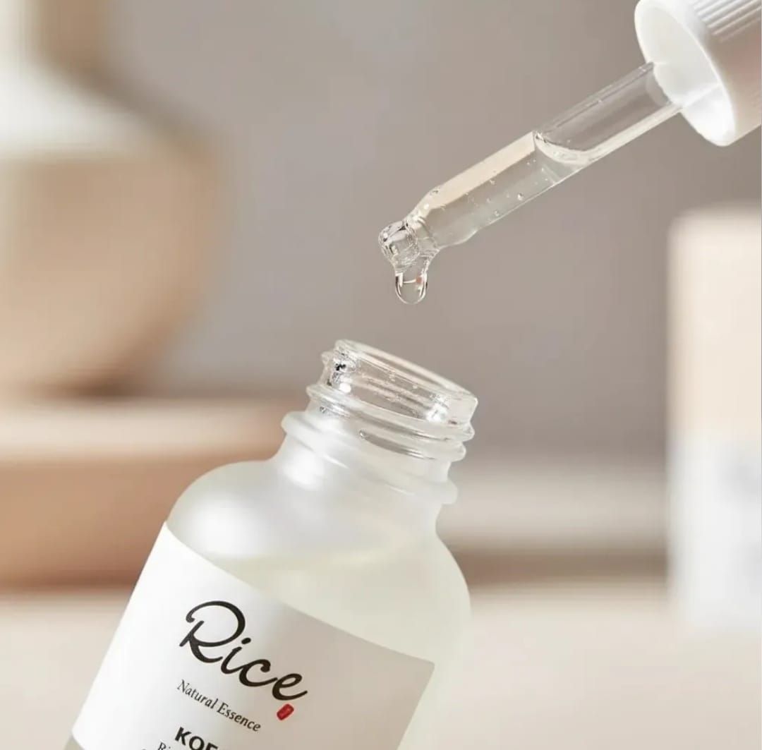 Esteticista aplicando un tratamiento facial a una clienta en una luminosa sala de spa.