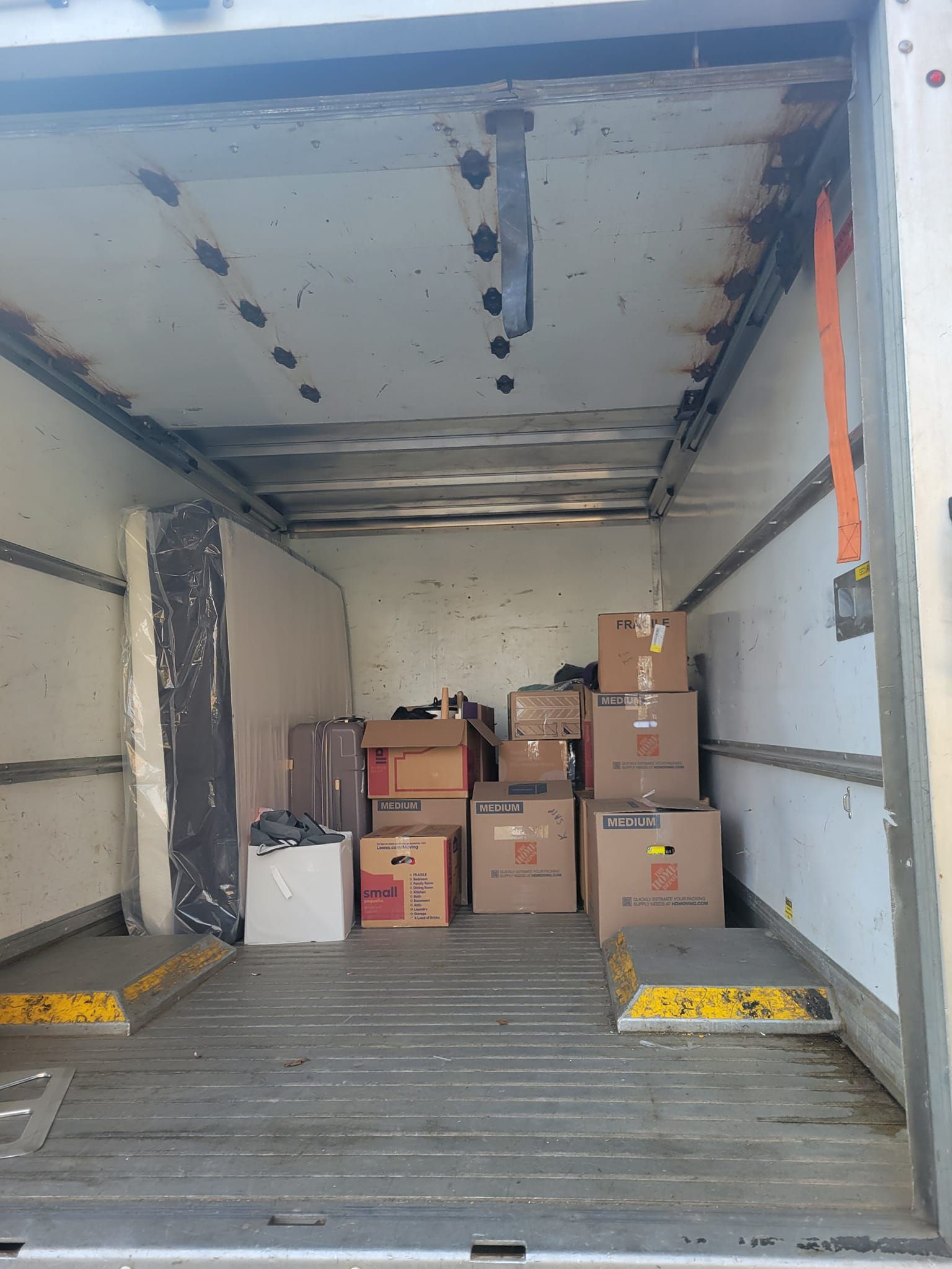 The inside of a moving truck filled with cardboard boxes