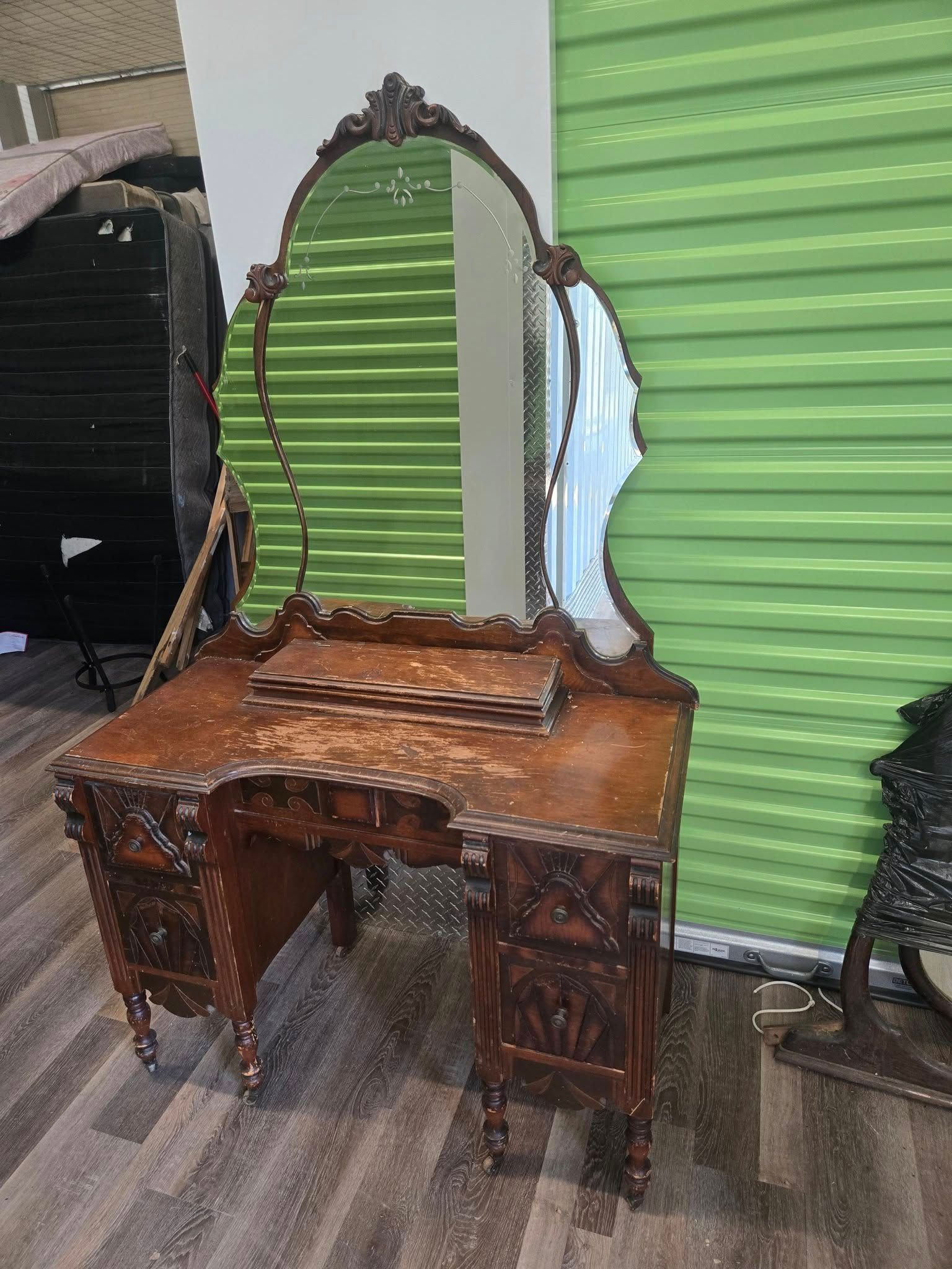 A wooden vanity with a mirror on top of it.